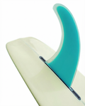 Quilha Polyvalent 10.5" da Lufi na cor Turquesa, instalada na caixa central de um longboard creme