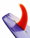 Quilha Polyvalent 10.5" da Lufi na cor Vermelho Fluor, instalada na caixa central de um longboard roxo translúcido
