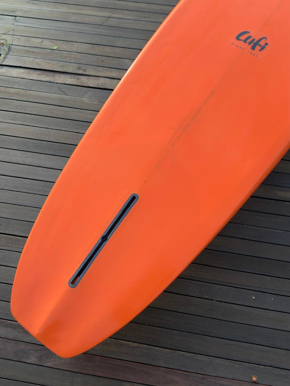 Longboard Lufi One Piece 9'2" seminovo, laranja: rabeta pelo fundo, com a caixa de quilha Futures vazia.