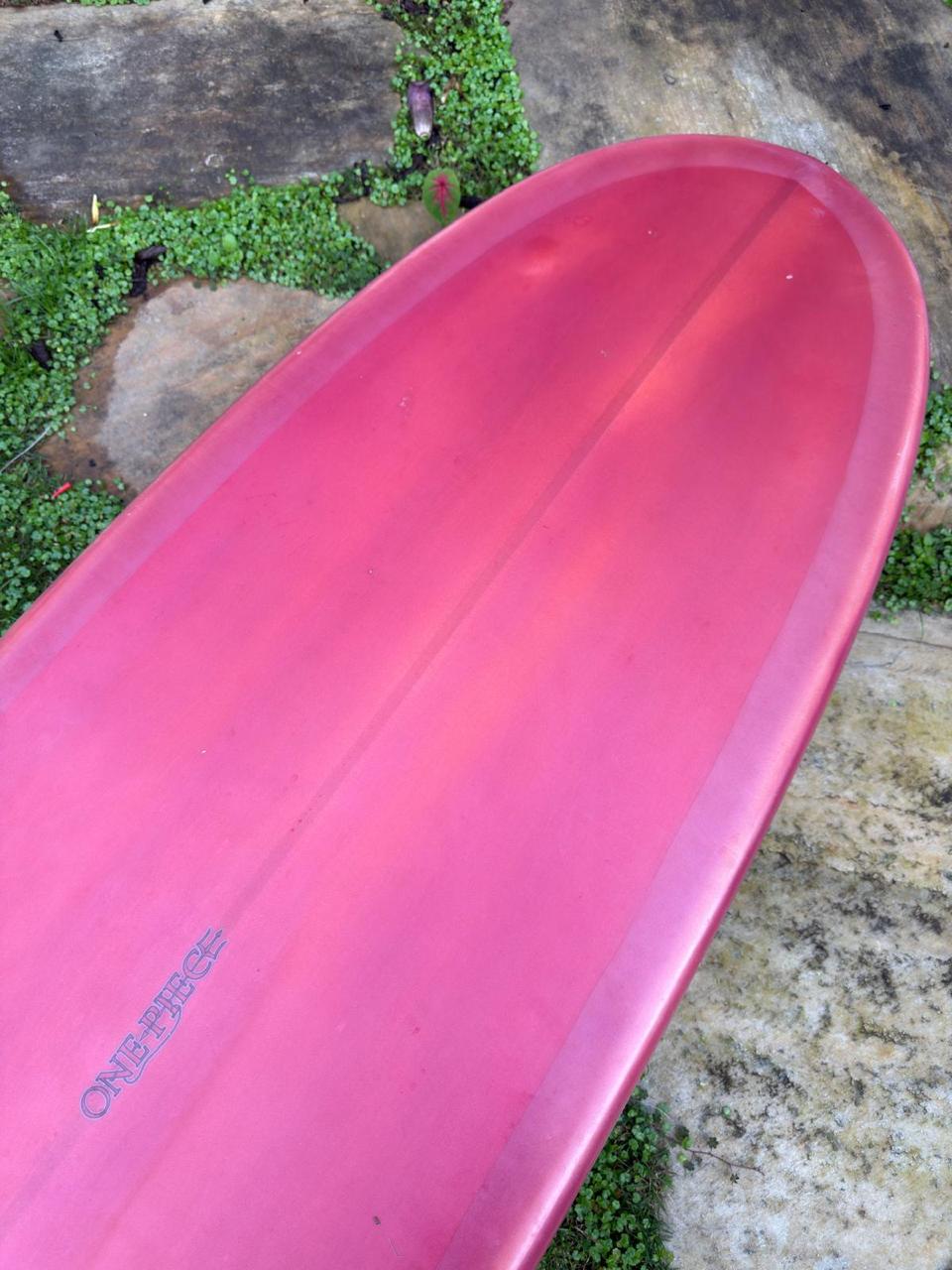 Longboard Lufi One Piece 9'2" seminovo, mauvee: bico pelo fundo, com o logo do modelo no filete.