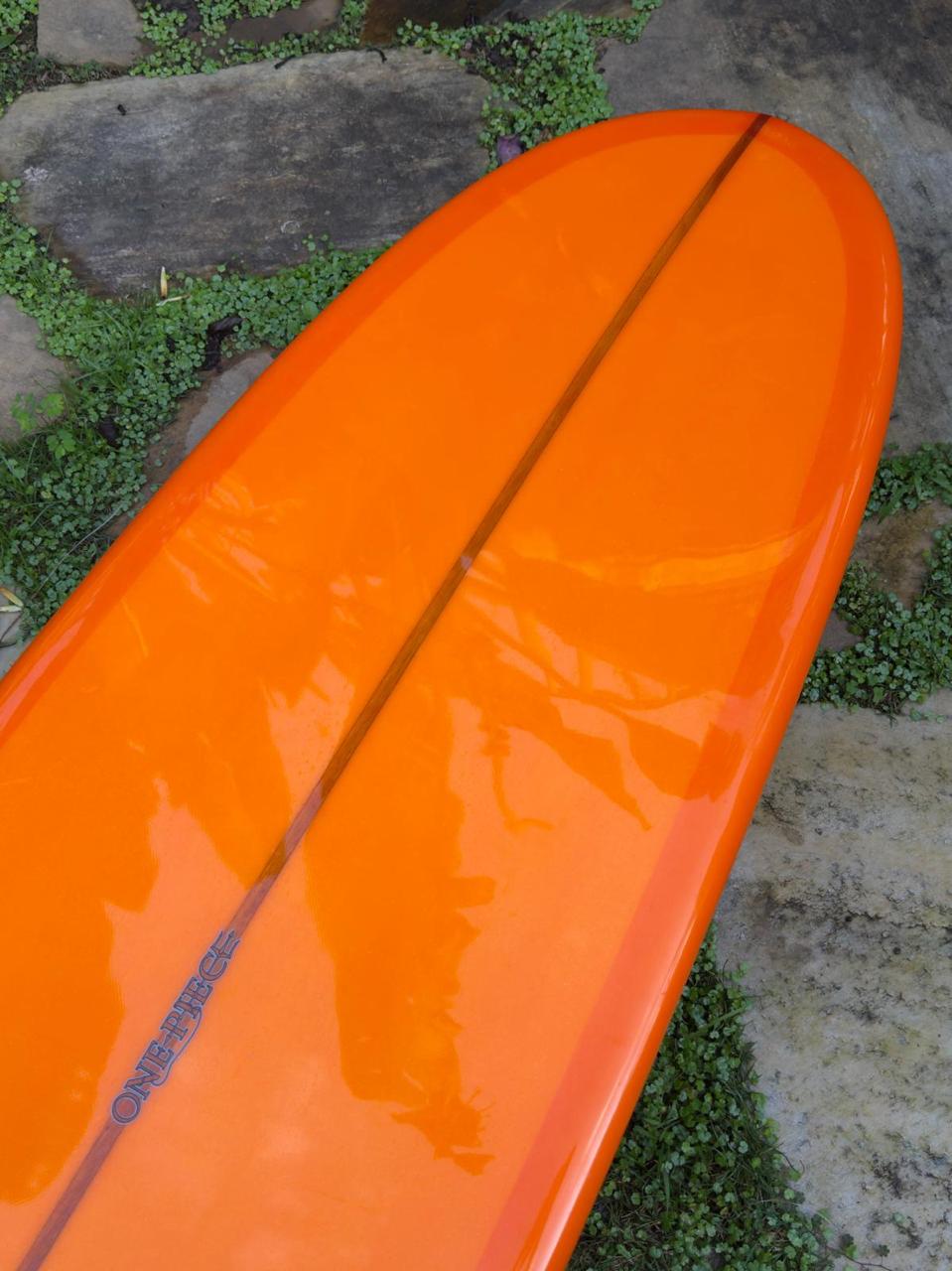 Longboard Lufi One Piece 9'4" seminovo, laranja: bico pelo fundo, com o logo do modelo no filete.