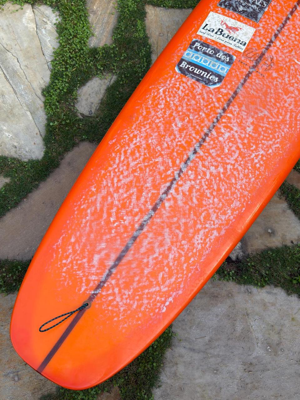 Longboard Lufi One Piece 9'4" seminovo, laranja: rabeta pelo deck, com plug de leash, parafina e adesivos do surfista anterior.