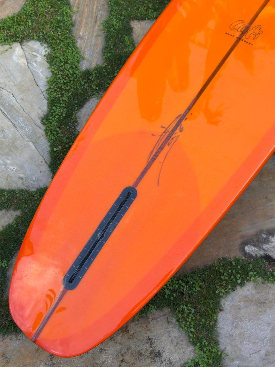 Longboard Lufi One Piece 9'4" seminovo, laranja: rabeta pelo fundo, com a caixa de quilha Futures vazia.