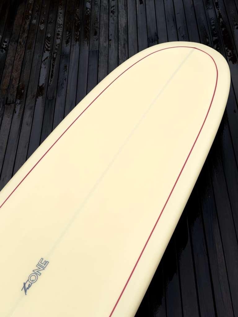 Longboard Lufi The Special One 9'10" seminovo, eggnog: bico com o logo The One gravado no filete.